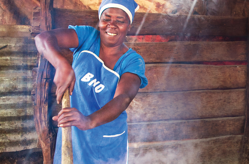 A volunteer cooks at school where her children are enrolled in our Children's Feeding Initiative.