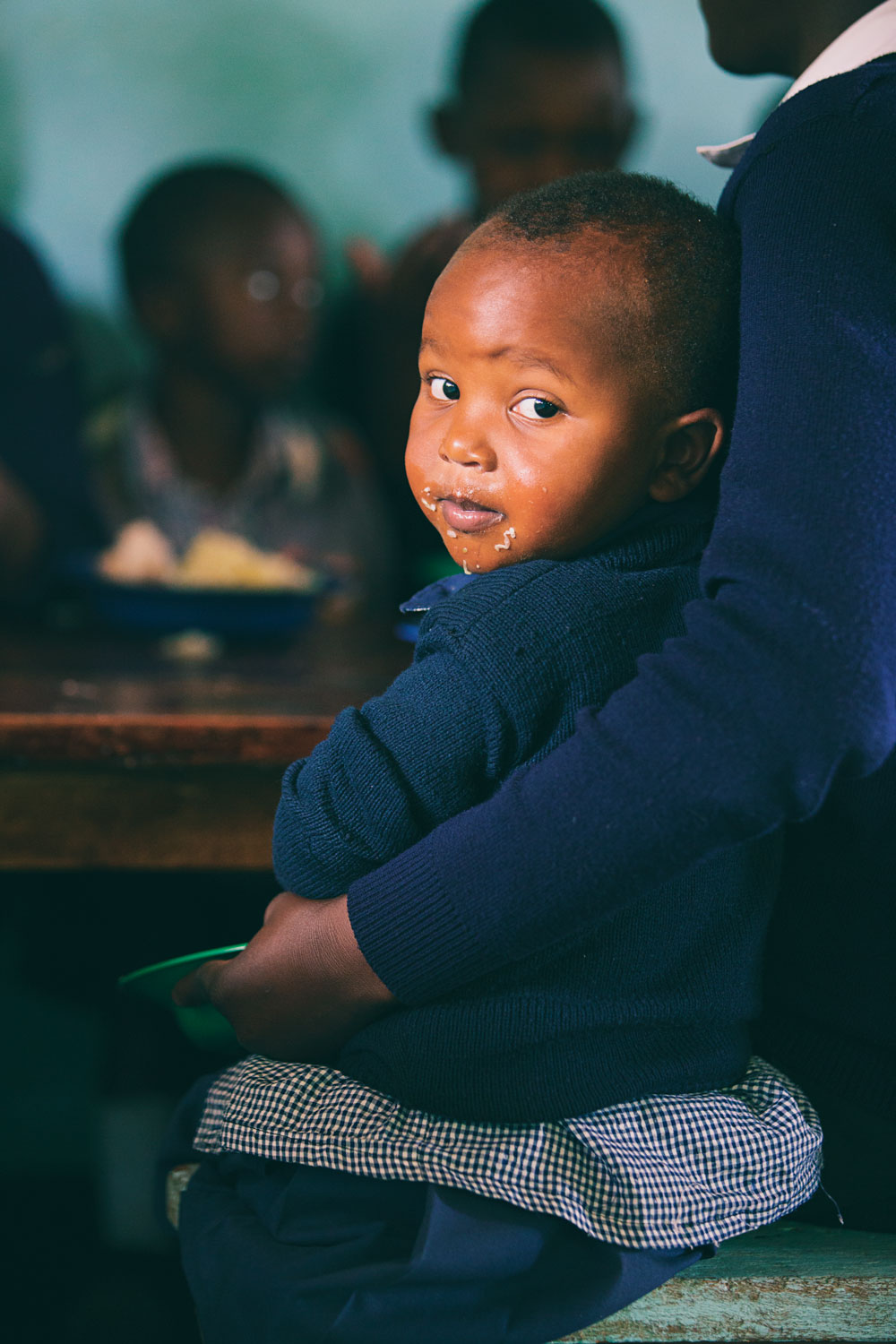 A young boy in Tanzania is happy after a nutritious meal.