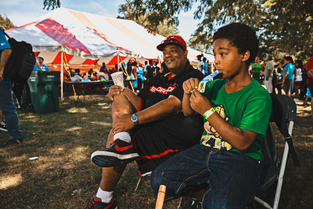 Larry Delaney and his son relax in the shade at the event.